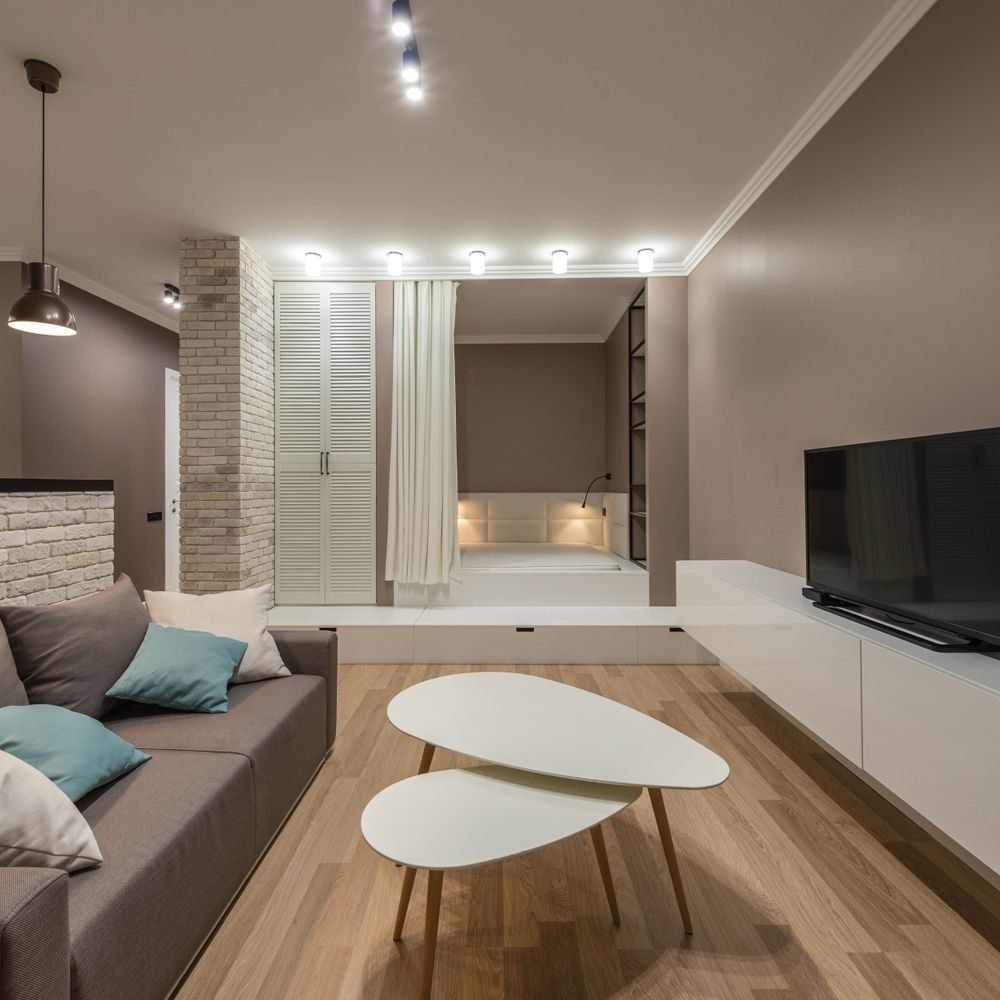 Storage ottoman used as a coffee table and extra seat in a small multifunctional living room