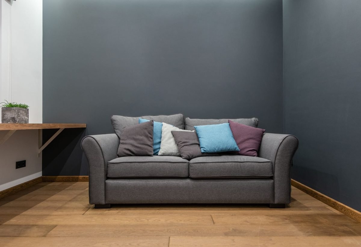 Compact loveseat with low arms fitting neatly against a wall in a tiny living room