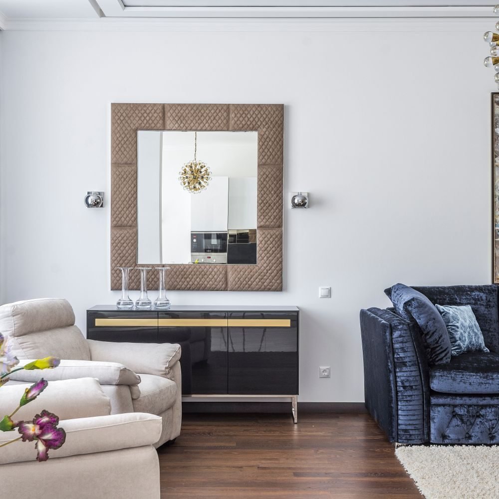 Large mirror placed across from a window reflecting daylight in a bright small living room