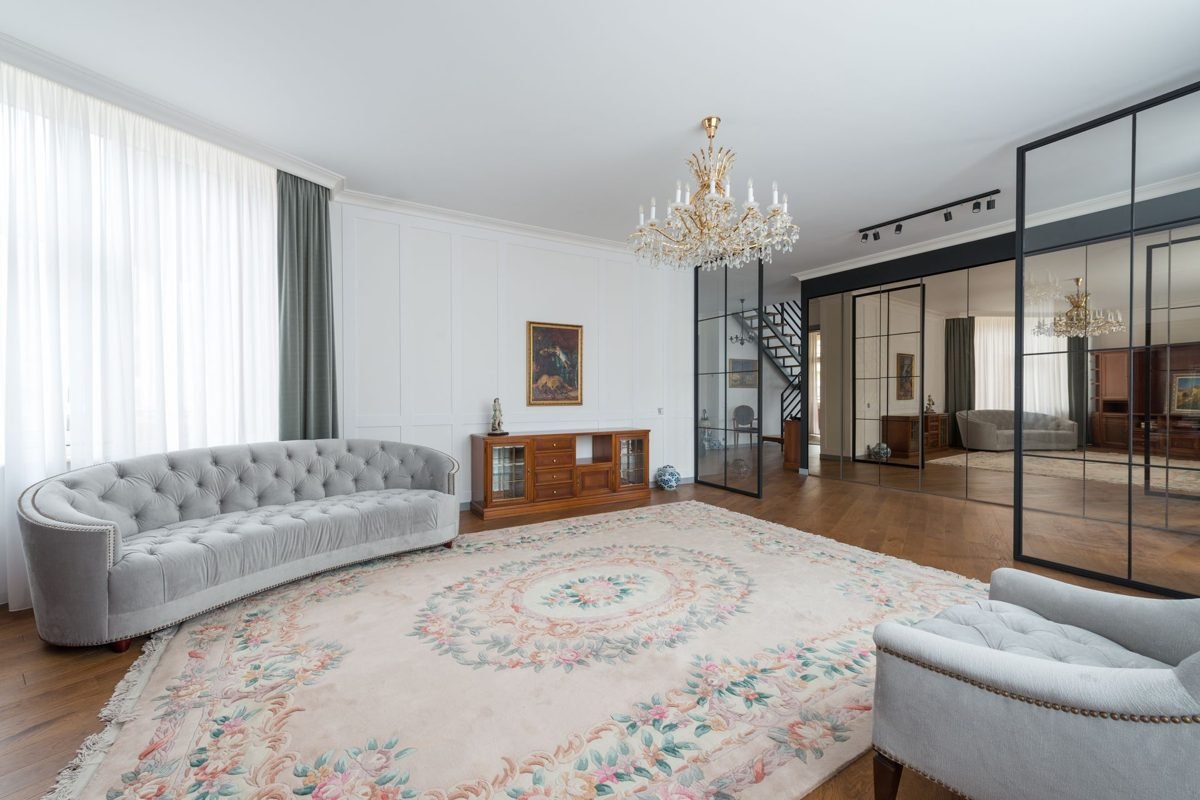 Large light-colored rug under the front legs of a sofa and chairs in a small living room