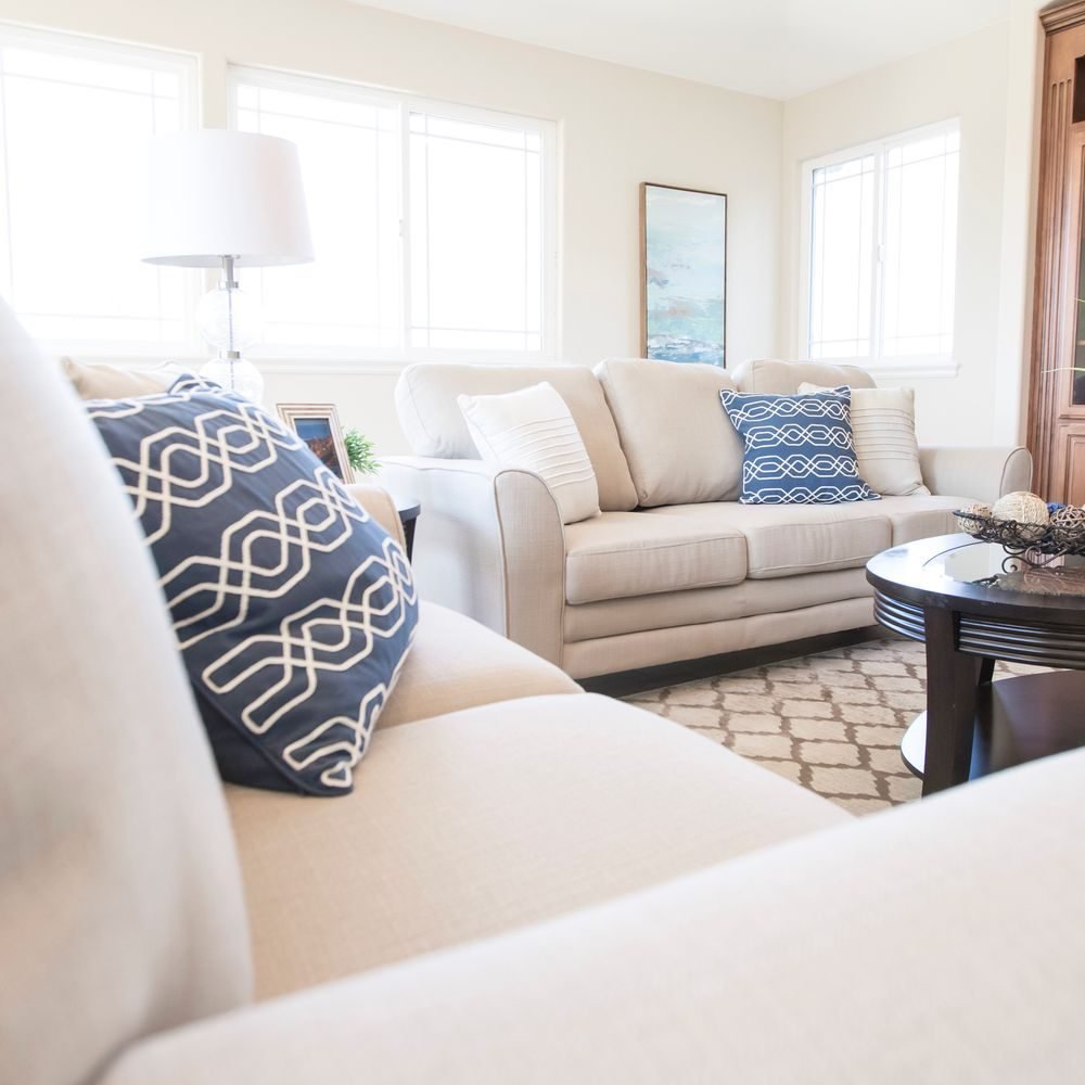 Small living room with a limited color palette of cream, beige, and soft blue pillows and decor
