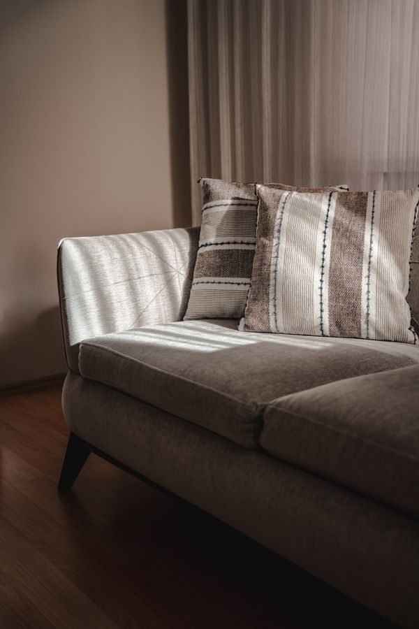 Sofa and armchair with exposed wooden legs showing the floor in an open small living room