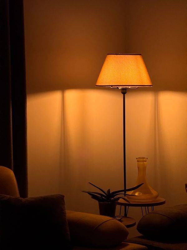 Layered lighting with a floor lamp and table lamp creating cozy zones in a small living room