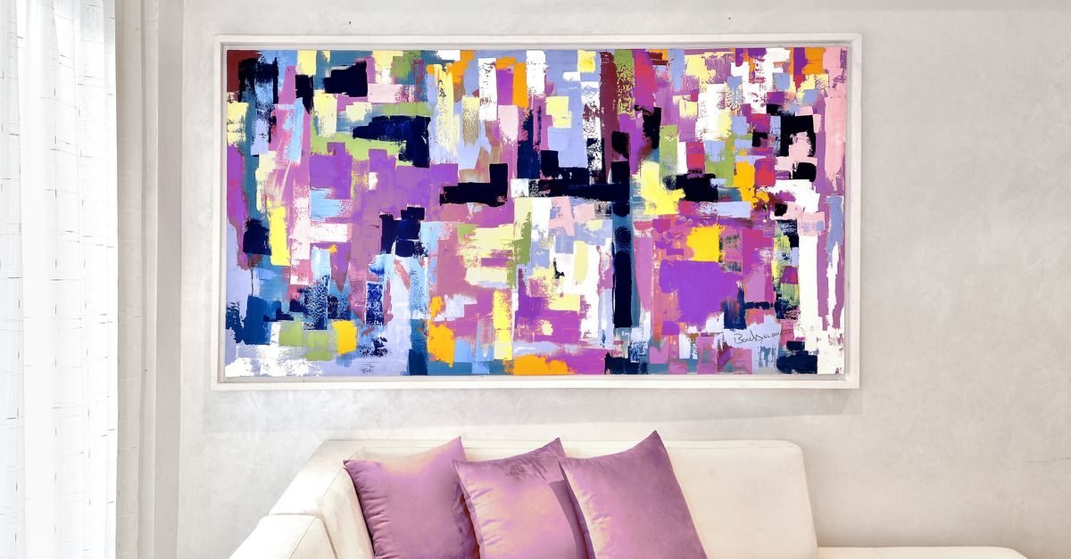 One large framed art piece above a sofa as a bold focal point in a small living room