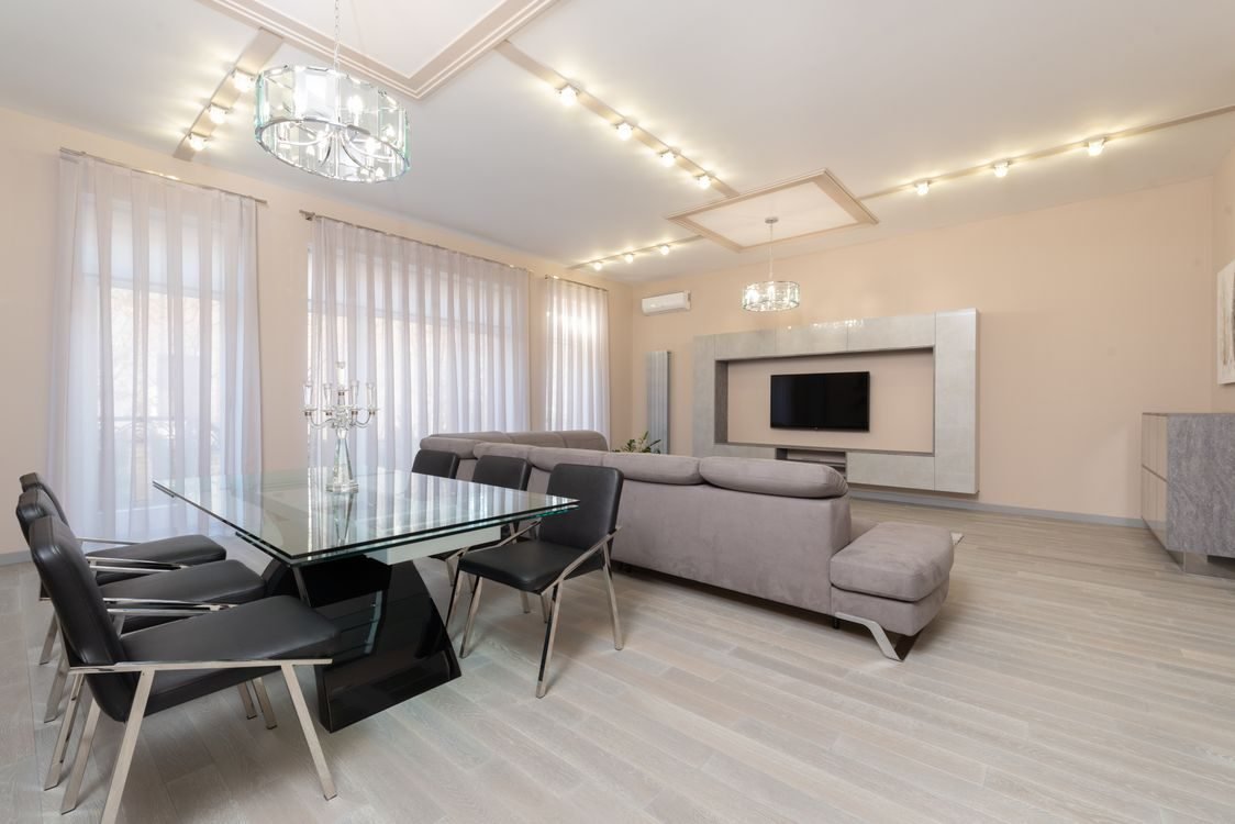 Glass coffee table and clear side table keeping sight lines open in a small bright living room